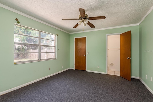 unfurnished bedroom with a textured ceiling, dark carpet, ceiling fan, and crown molding