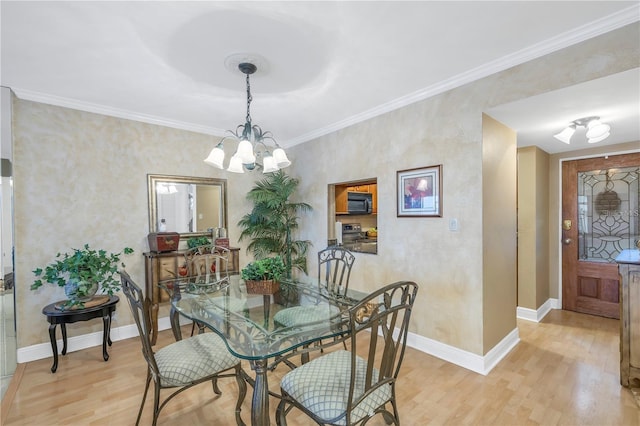 dining area featuring crown molding, light hardwood / wood-style flooring, and a chandelier