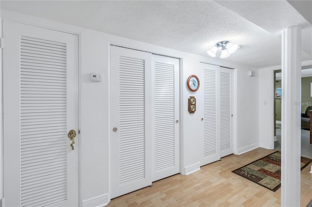 foyer with a textured ceiling and light wood-type flooring