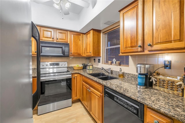 kitchen with black appliances, sink, ceiling fan, dark stone countertops, and tasteful backsplash