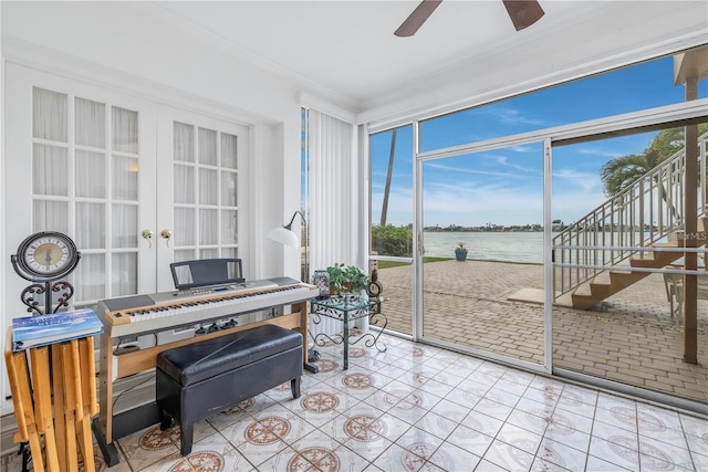 sunroom / solarium with french doors, a water view, and ceiling fan