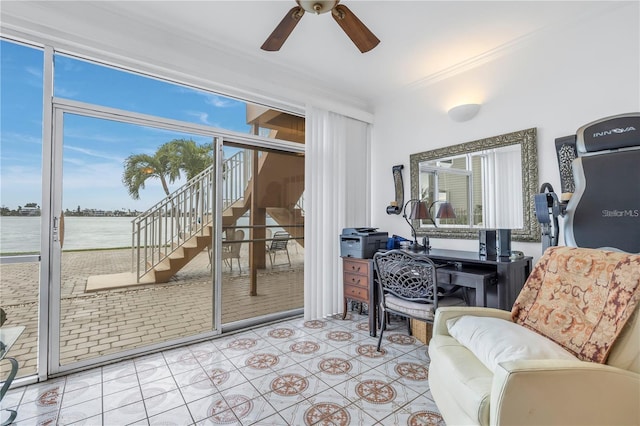 sunroom with ceiling fan and a water view