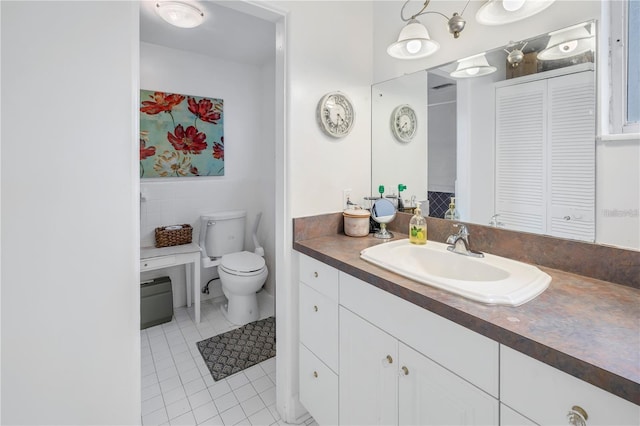 bathroom with tile patterned flooring, vanity, and toilet