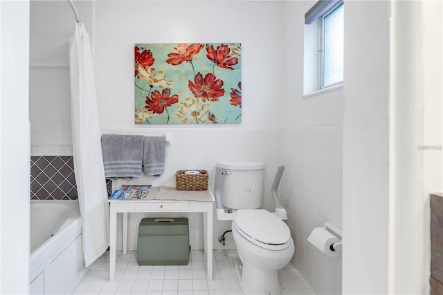 bathroom featuring toilet, shower / bath combo with shower curtain, and tile walls