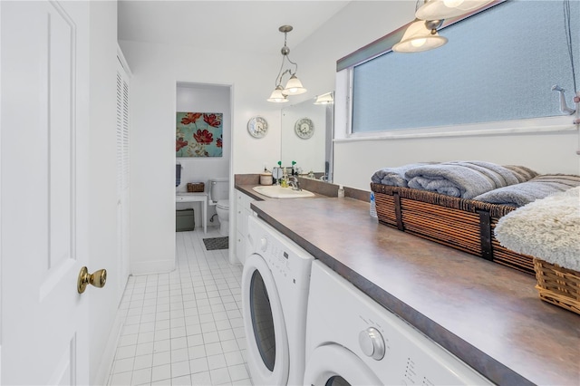 laundry room with light tile patterned floors, sink, and washing machine and clothes dryer