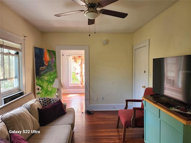 living room featuring dark wood-type flooring and ceiling fan