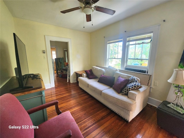 living room with dark wood-type flooring and ceiling fan