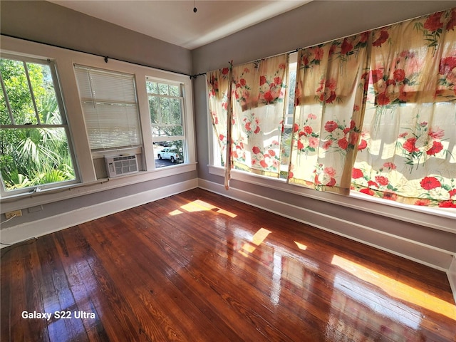 unfurnished room with hardwood / wood-style floors and a healthy amount of sunlight