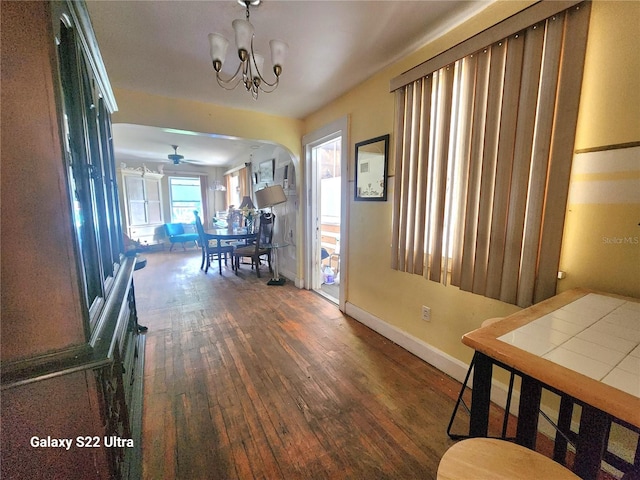 hall with dark hardwood / wood-style flooring and a chandelier