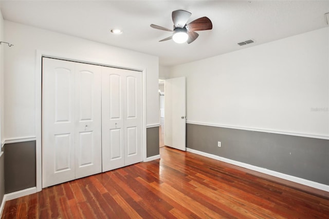 unfurnished bedroom with a closet, ceiling fan, and dark hardwood / wood-style flooring