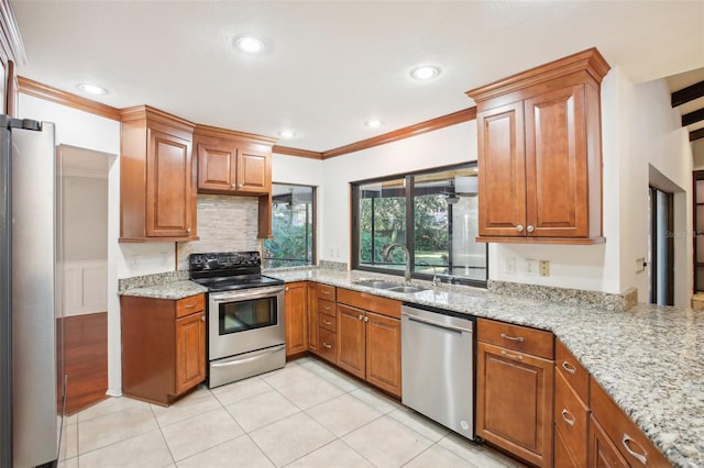 kitchen featuring light stone countertops, sink, stainless steel appliances, and ornamental molding