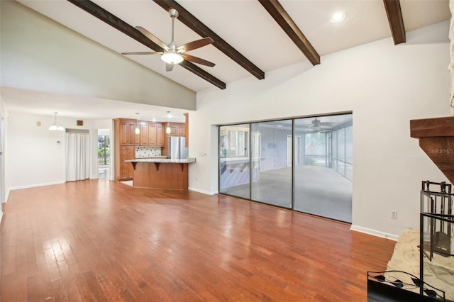 unfurnished living room with beamed ceiling, hardwood / wood-style flooring, high vaulted ceiling, and ceiling fan