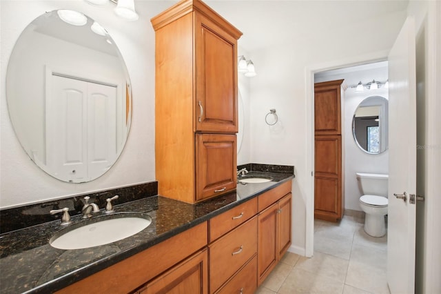 bathroom featuring tile patterned floors, vanity, and toilet