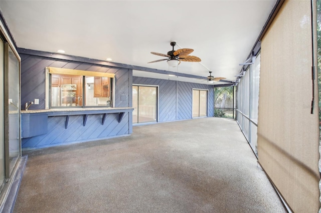 unfurnished sunroom with ceiling fan