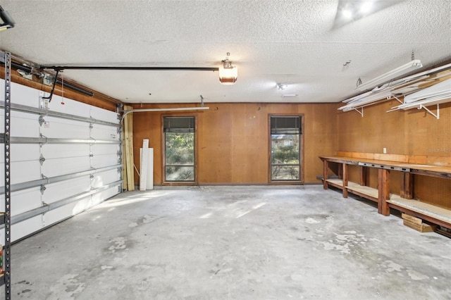 garage with wood walls and a garage door opener