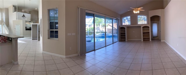 spare room featuring ceiling fan, light tile patterned flooring, and vaulted ceiling