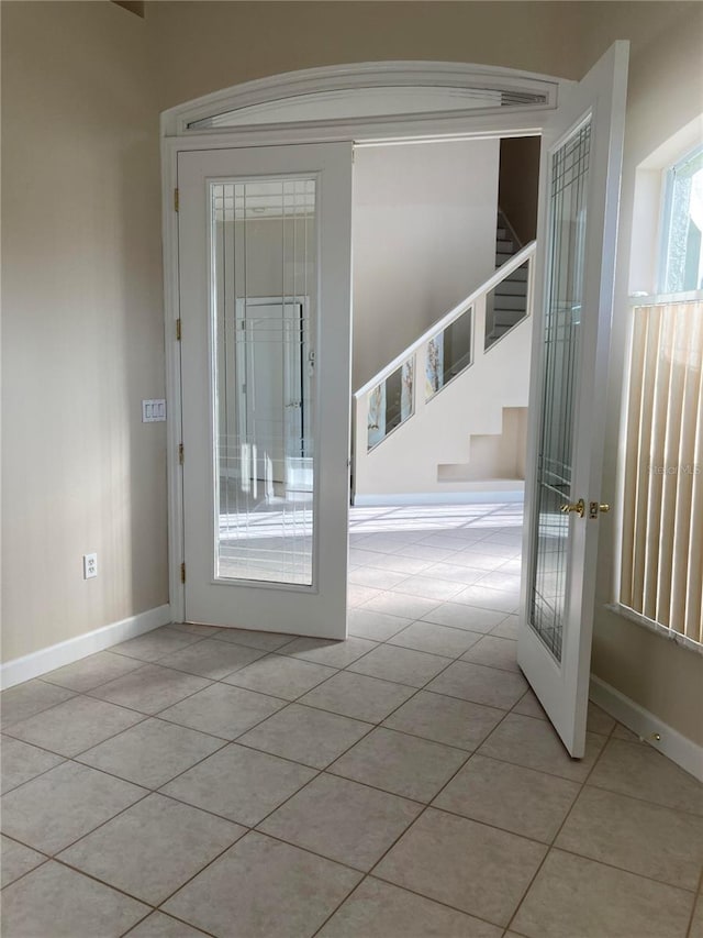 doorway to outside with french doors and light tile patterned flooring