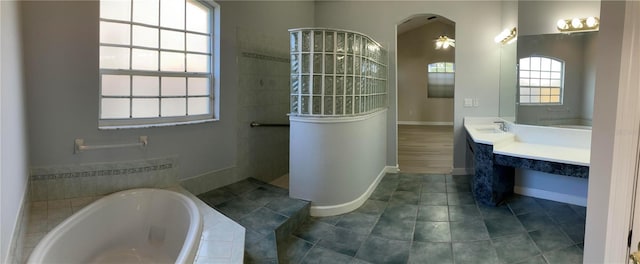 bathroom with vanity and tiled bath