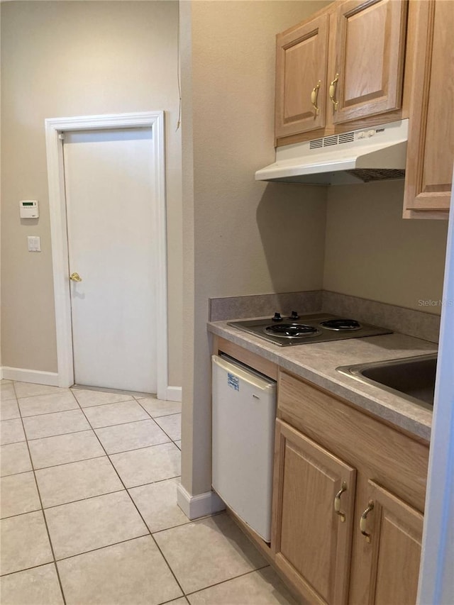 kitchen featuring sink, stainless steel cooktop, white dishwasher, light brown cabinetry, and light tile patterned floors