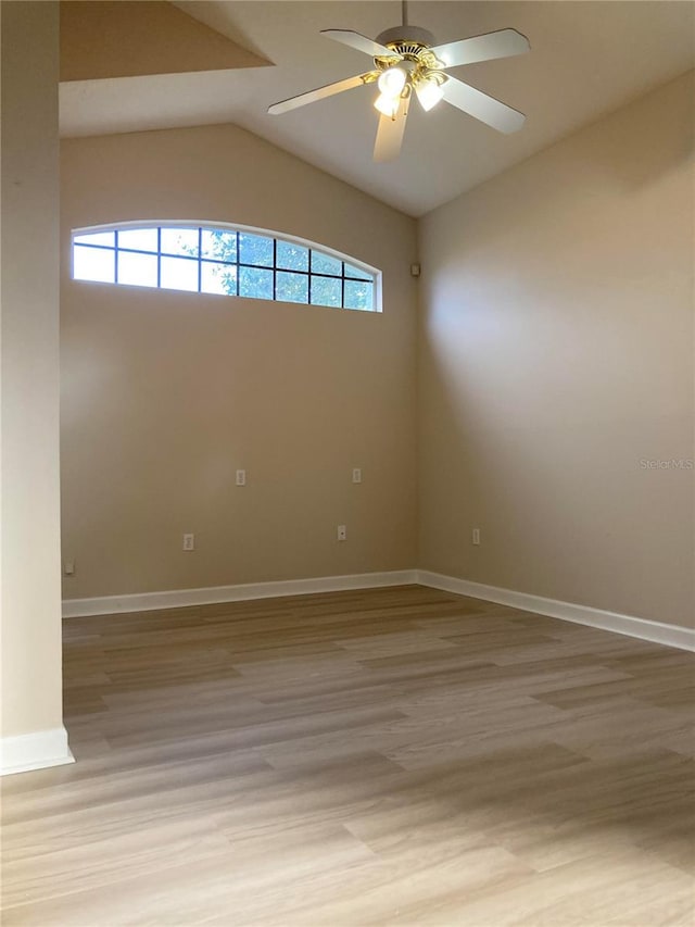 spare room featuring light hardwood / wood-style flooring, vaulted ceiling, and ceiling fan