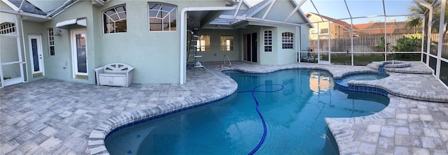 view of pool with a patio area, a lanai, and an in ground hot tub