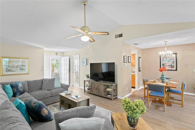 living room with ceiling fan with notable chandelier, vaulted ceiling, a textured ceiling, and light hardwood / wood-style flooring