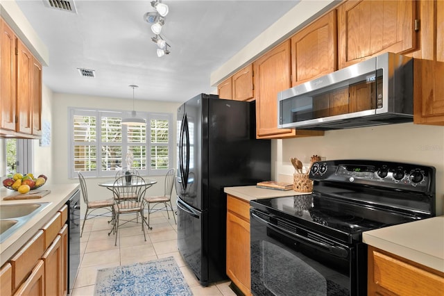 kitchen featuring black appliances, decorative light fixtures, and light tile patterned flooring