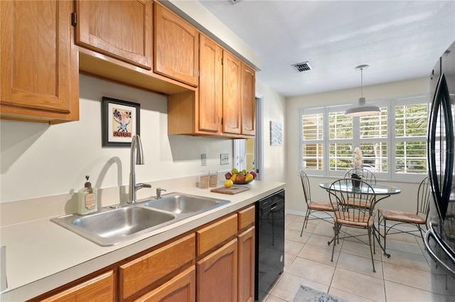 kitchen featuring pendant lighting, dishwasher, sink, light tile patterned flooring, and stainless steel refrigerator