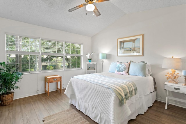 bedroom featuring a textured ceiling, ceiling fan, vaulted ceiling, and hardwood / wood-style flooring