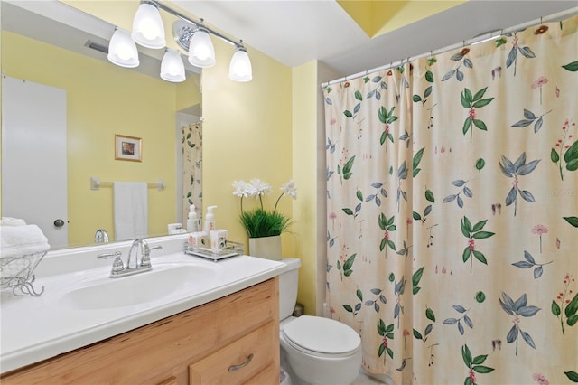 bathroom featuring vanity, toilet, and walk in shower