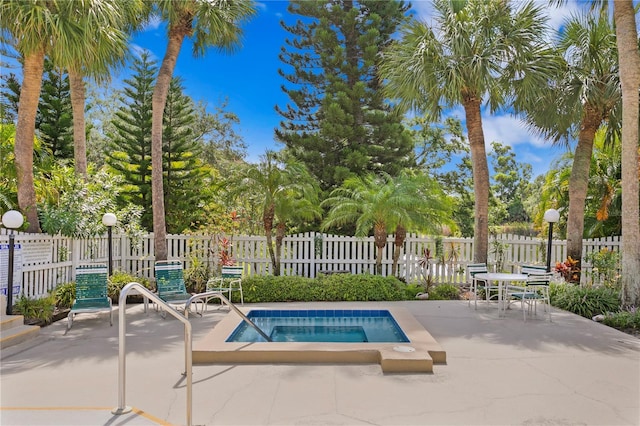 view of swimming pool featuring a patio and a hot tub