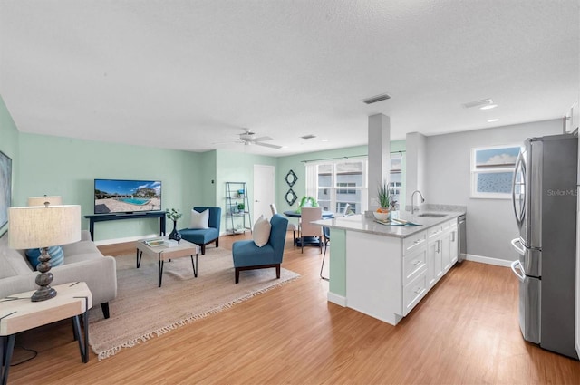 kitchen featuring plenty of natural light, light wood-type flooring, white cabinetry, and stainless steel appliances