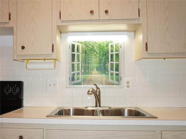 kitchen with tasteful backsplash, light brown cabinets, and sink