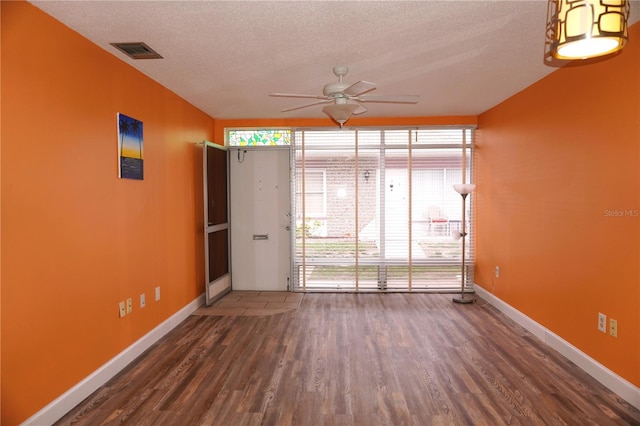 spare room with ceiling fan, dark hardwood / wood-style flooring, and a textured ceiling