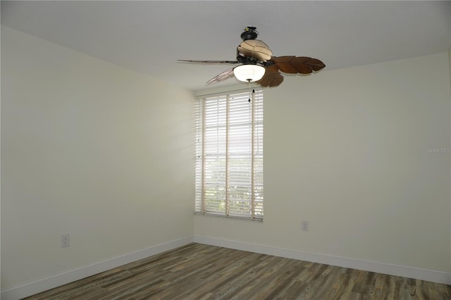 empty room with ceiling fan and dark hardwood / wood-style flooring