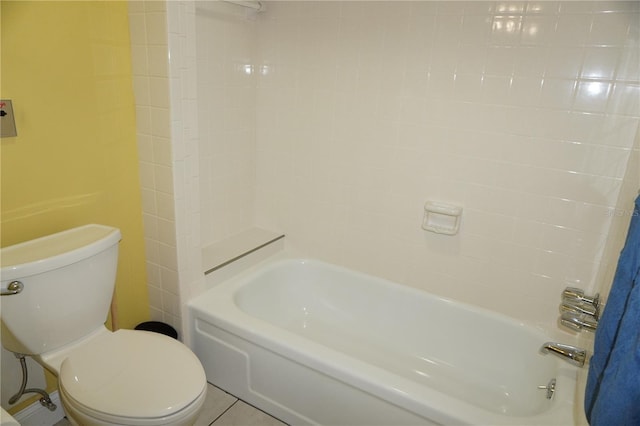 bathroom with tile patterned floors, bathing tub / shower combination, and toilet