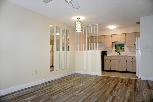 4349 Tahitian Gardens Cir Unit G, Holiday, FL 34691 - kitchen featuring freestanding refrigerator, dark wood finished floors, ceiling fan, a sink, and light countertops