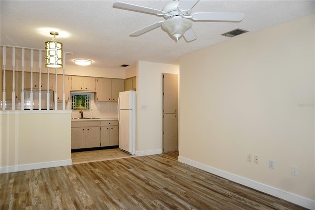 4349 Tahitian Gardens Cir Unit G, Holiday, FL 34691 - kitchen featuring freestanding refrigerator, a sink, light wood finished floors, ceiling fan, and light countertops