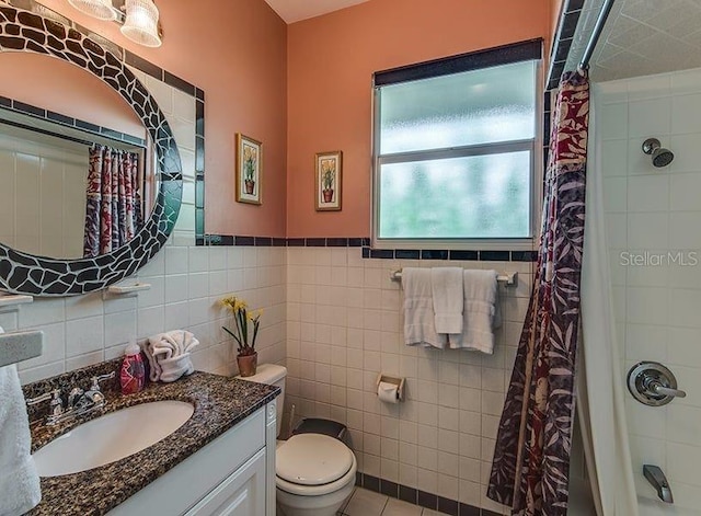 full bathroom featuring vanity, shower / tub combo with curtain, tile walls, tile patterned flooring, and toilet