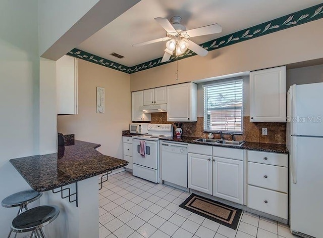 kitchen featuring decorative backsplash, white cabinetry, and white appliances