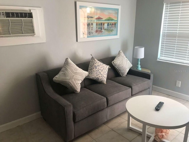 living room featuring light tile patterned floors and an AC wall unit