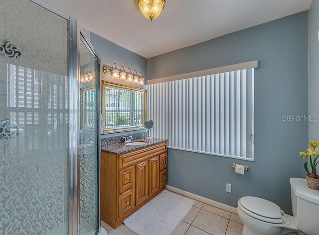 bathroom with toilet, vanity, tile patterned floors, and an enclosed shower