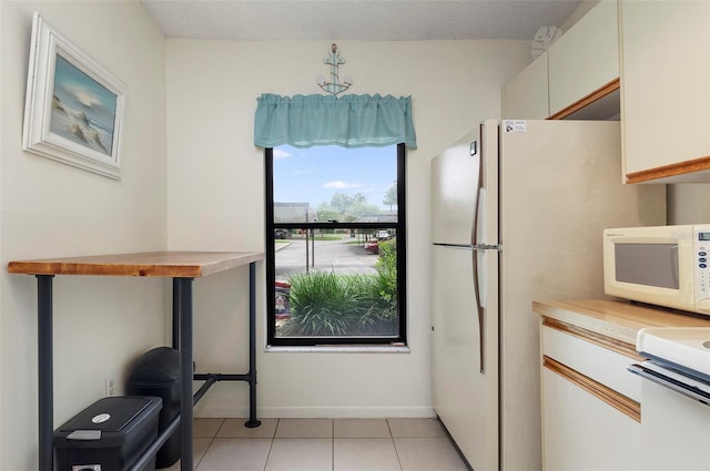 kitchen with white cabinets and light tile patterned floors