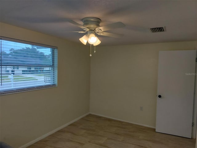 spare room with ceiling fan and light wood-type flooring