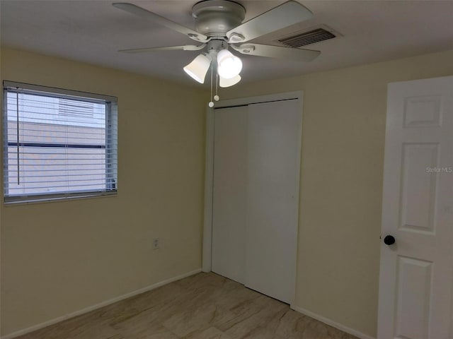 unfurnished bedroom featuring ceiling fan and a closet