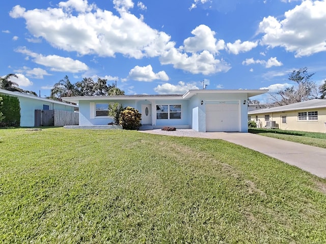 ranch-style house featuring cooling unit, a garage, and a front yard