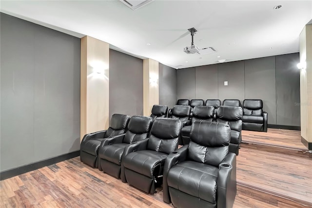 home theater with light wood-style floors and a decorative wall