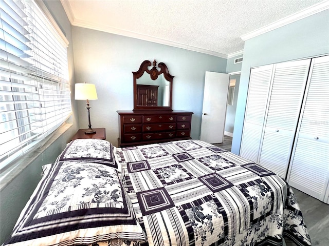 bedroom featuring crown molding, a textured ceiling, visible vents, and a closet