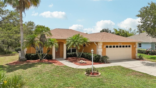 mediterranean / spanish house with a front yard and a garage