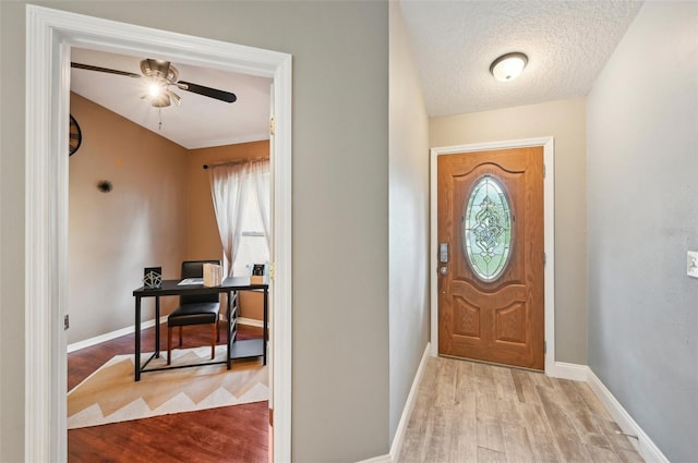 entryway featuring ceiling fan, a textured ceiling, and light hardwood / wood-style flooring